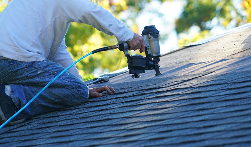 Man on roof with nail gun service-04