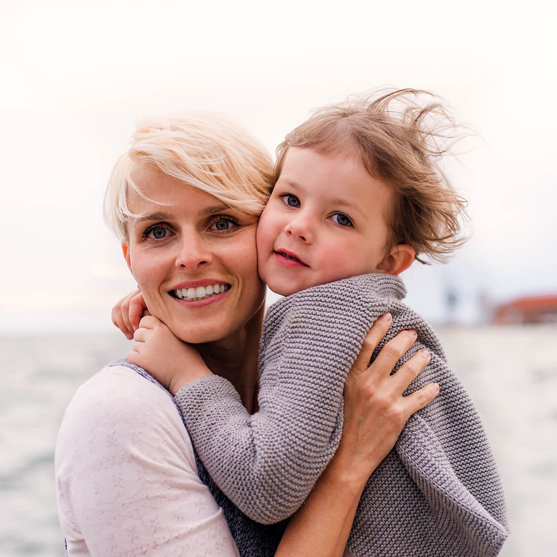 young-mother-with-small-daughter-standing-outdoors-1129×1129